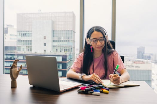 pexels photo 34224991 34224991 Young woman wearing headphones, writing in notebook at office desk with city view.