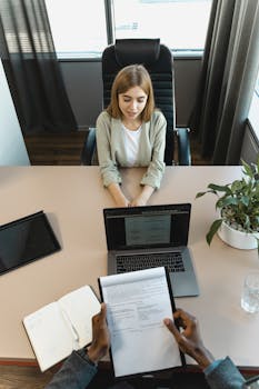 pexels photo 5439152 5439152 High-angle view of a job interview in a modern office setting, capturing professionalism.
