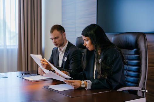pexels photo 8847133 8847133 Two business professionals in a conference room engaged in a meeting and document review.